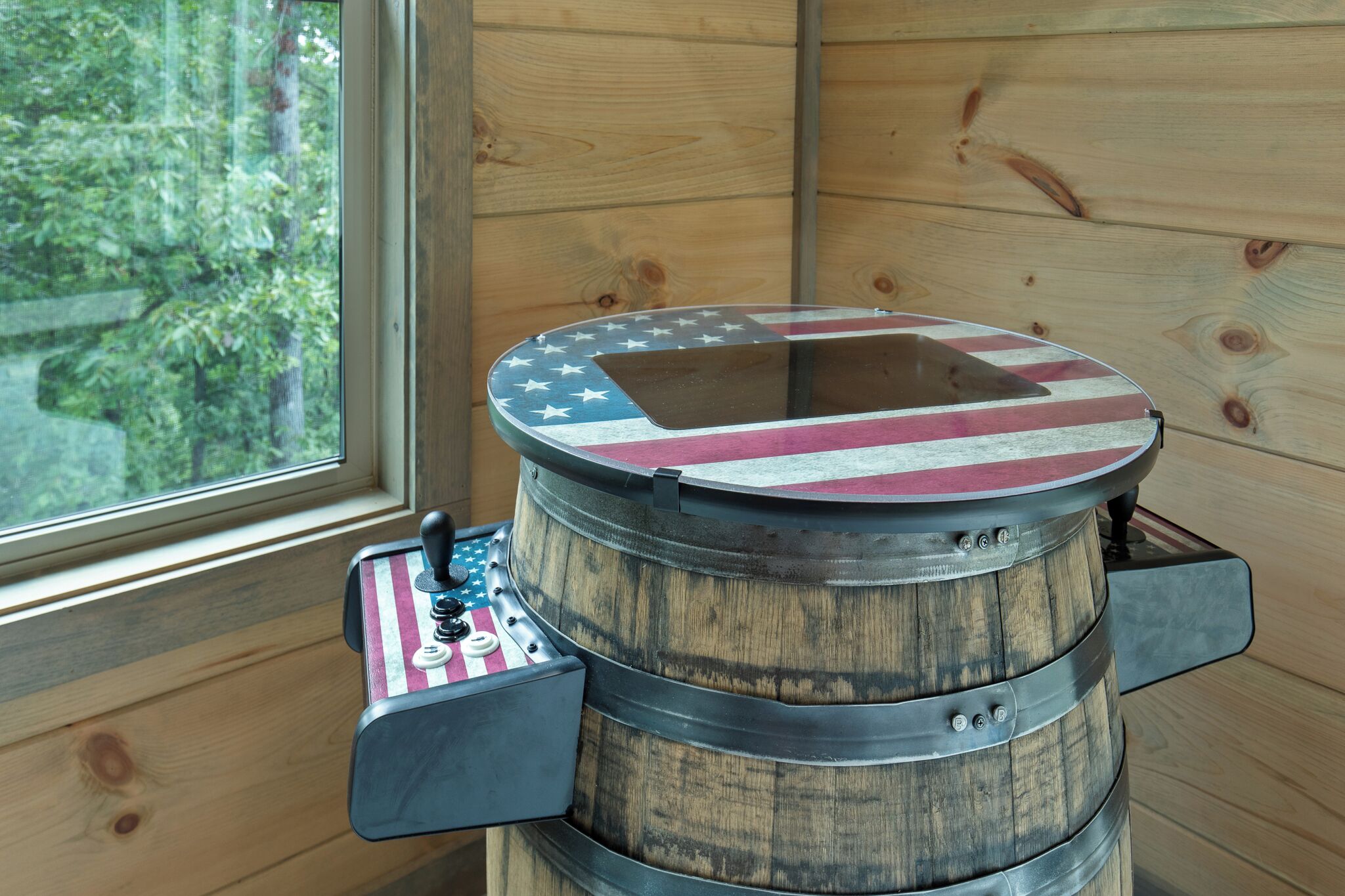 Un barril de madera rústico con tapa metálica, decorado con un diseño de la bandera estadounidense.