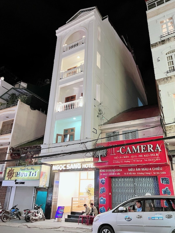 A multi-story building with a prominent white facade and balconies.