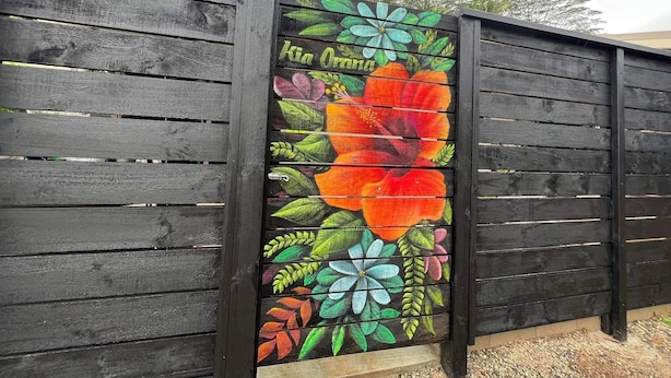 Una cerca de madera con un mural floral colorido.