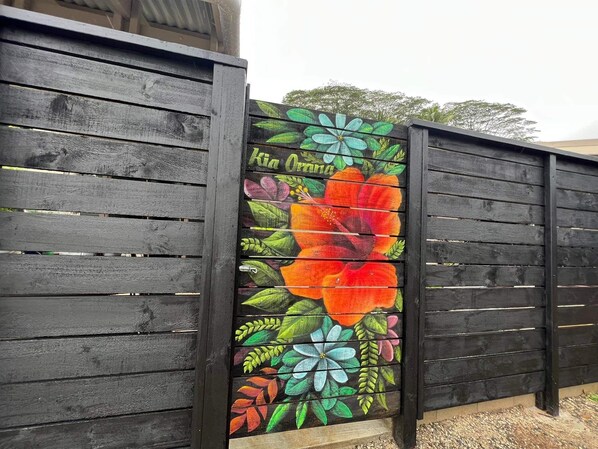 Una cerca de madera con un mural floral colorido.