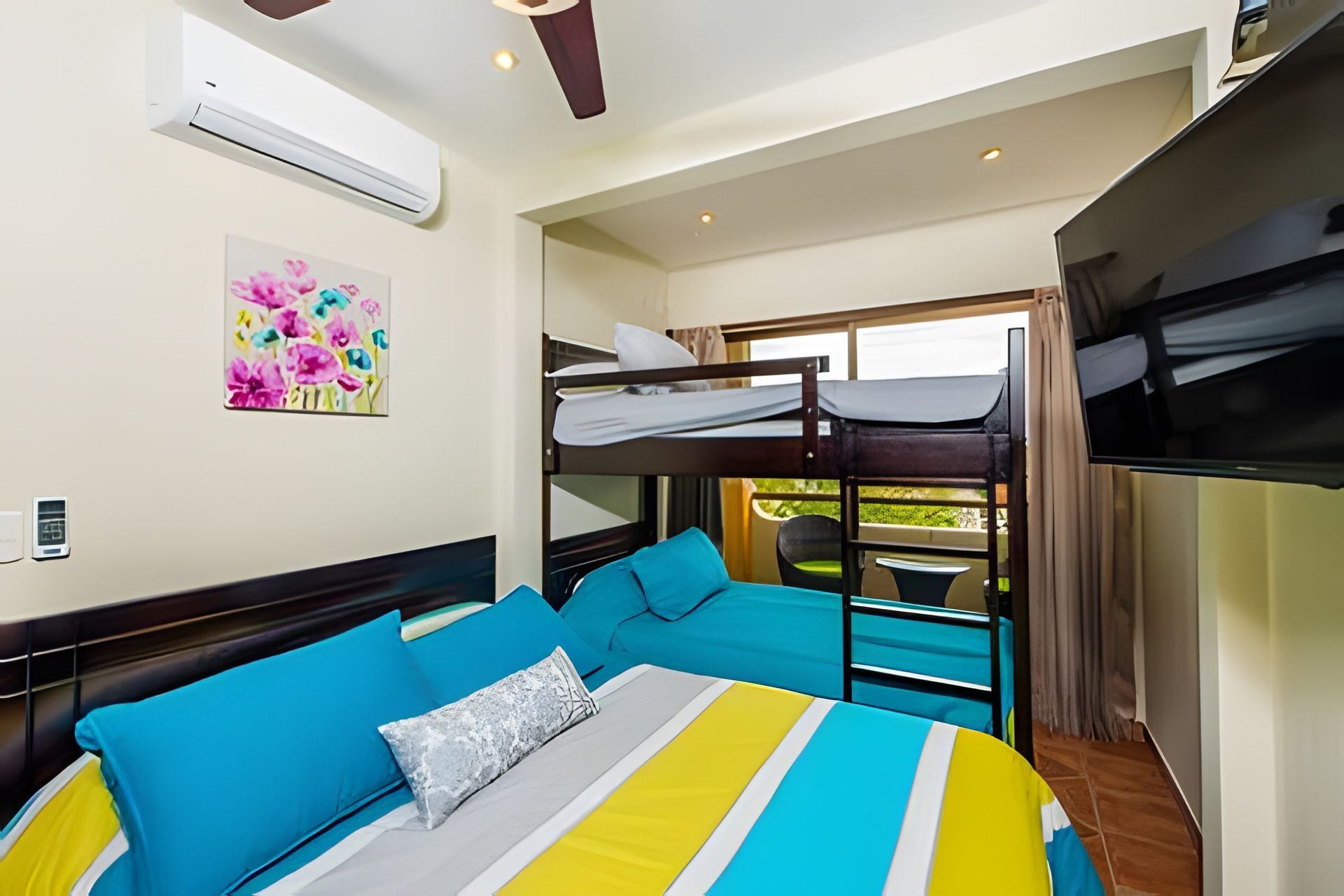 A bunk bed room with a bed, a TV, and a window.