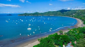 A coastal area with boats, a beach, and lush greenery. - Coco Sunset Hills 52 (Coco)