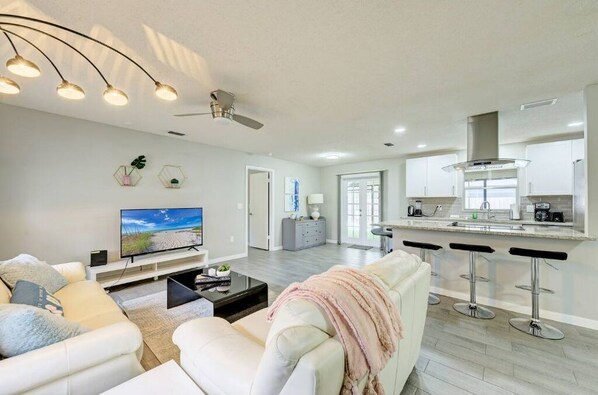 Relax in a spacious living area with a sofa set and flat-screen TV, or cook and dine at the large island and bar stools.