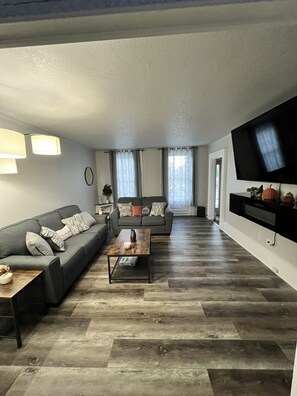 A living room with a sofa, coffee table, and TV. - Pet friendly, freshly renovated, 5 minute walk to beach in the heart of the city (Sheboygan)