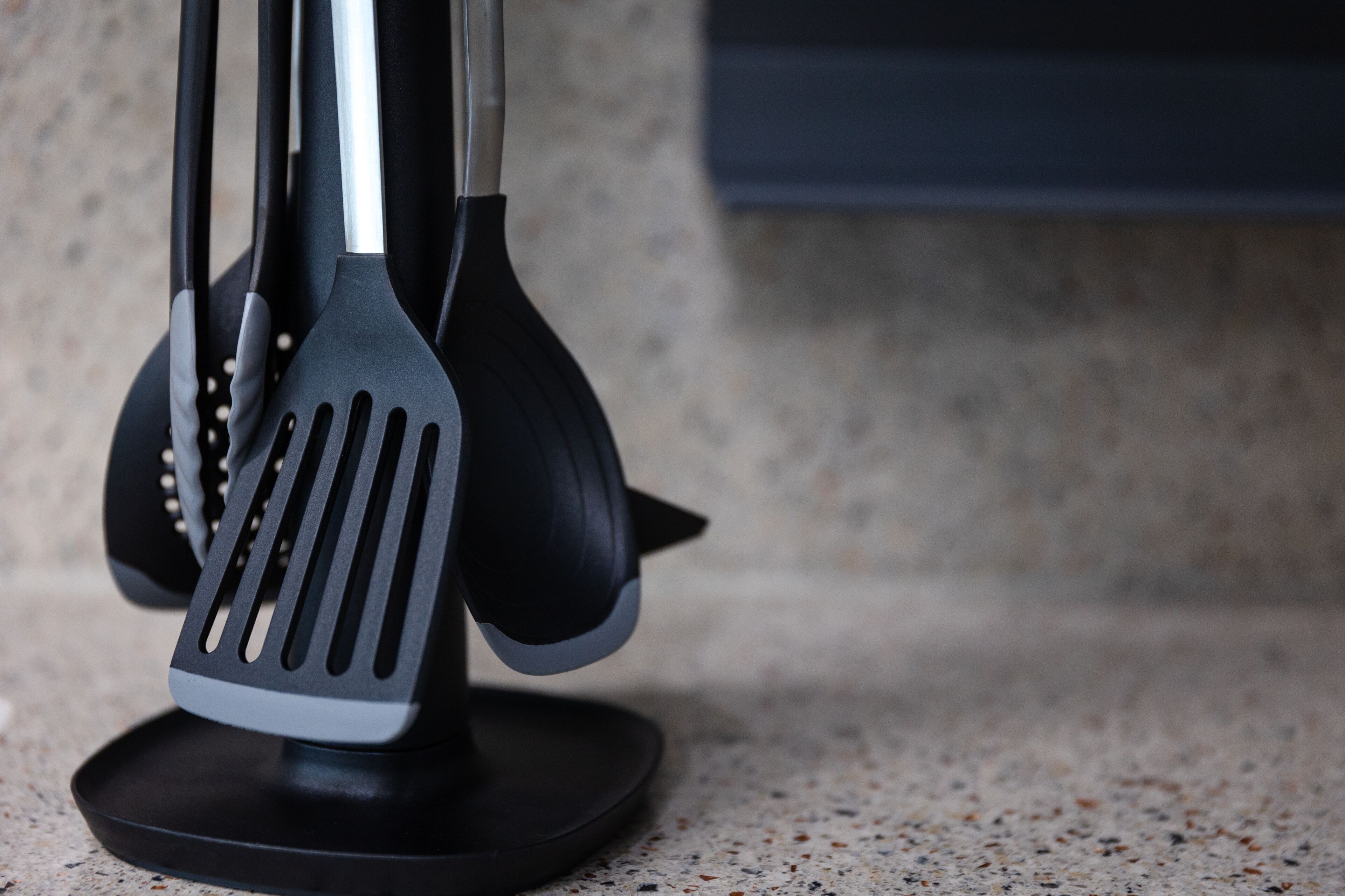 A kitchen utensil holder with a spatula and tongs.