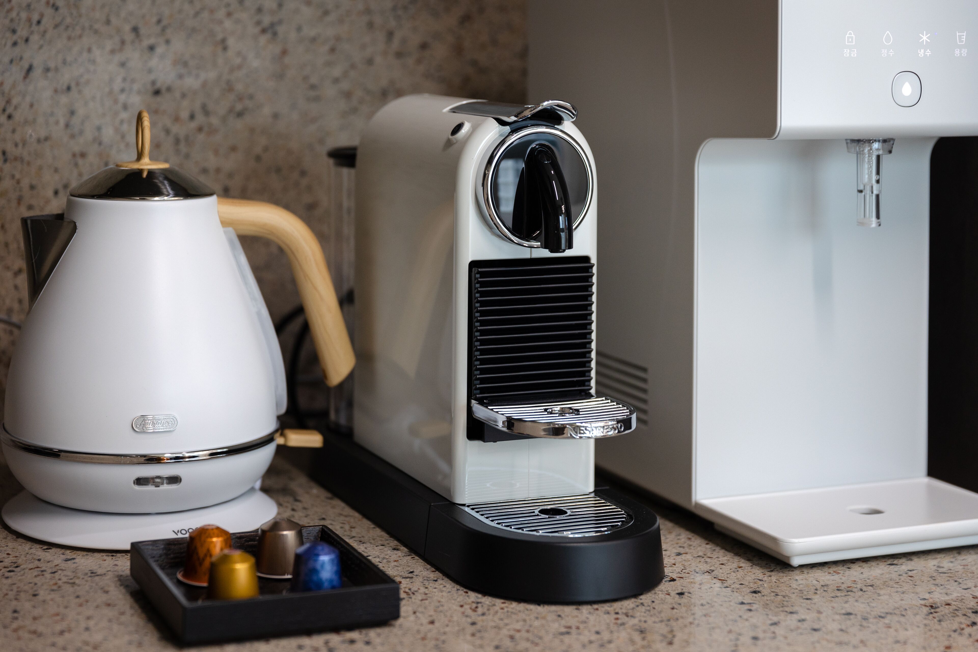 Een koffieapparaat met een waterdispenser en een koffiekan op een aanrecht.