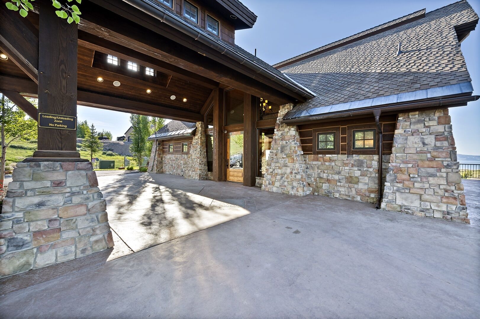 A stone building with a covered entrance and a stone chimney.