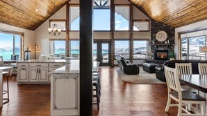 A spacious living area with a fireplace, large windows, and a view of a mountainous landscape. - Spectacular views of Bear Lake in a spacious private retreat on nearly 6 acres! (Fish Haven)