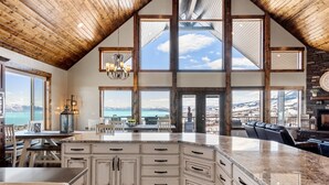 A spacious kitchen with a large island, high ceilings, and large windows offering views of a mountainous landscape. - Spectacular views of Bear Lake in a spacious private retreat on nearly 6 acres! (Fish Haven)