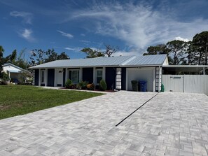 A residential building with a garage, a paved driveway, and a well-maintained lawn.