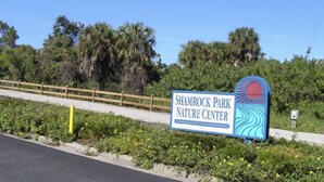 A sign for Shamrock Park Nature Center with a wooden fence and greenery in the background. - Beautiful family house in Venice, Fl. It is only a mile away from Shamrock Park  (Venice)