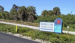 A sign for Shamrock Park Nature Center with a wooden fence and greenery in the background. - Beautiful family house in Venice, Fl. It is only a mile away from Shamrock Park  (Venice)