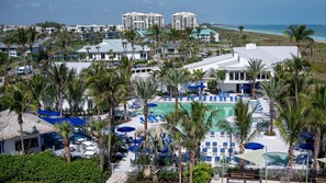 Ein Resort mit Poolbereich, Palmen und Blick auf den Strand.