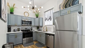 A modern kitchen with grey cabinets, stainless steel appliances, and a central island.