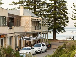 Enjoy a meal on the balcony overlooking the ocean, with outdoor seating and a scenic view.