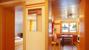 Une pièce comprenant un lit, un bureau, une chaise, une fenêtre et un ventilateur de plafond.