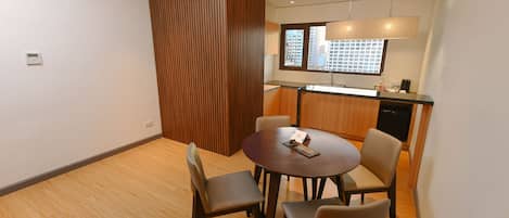 Cocina moderna con horno empotrado, ventana con vista a la ciudad y comedor con mesa redonda y cuatro sillas.