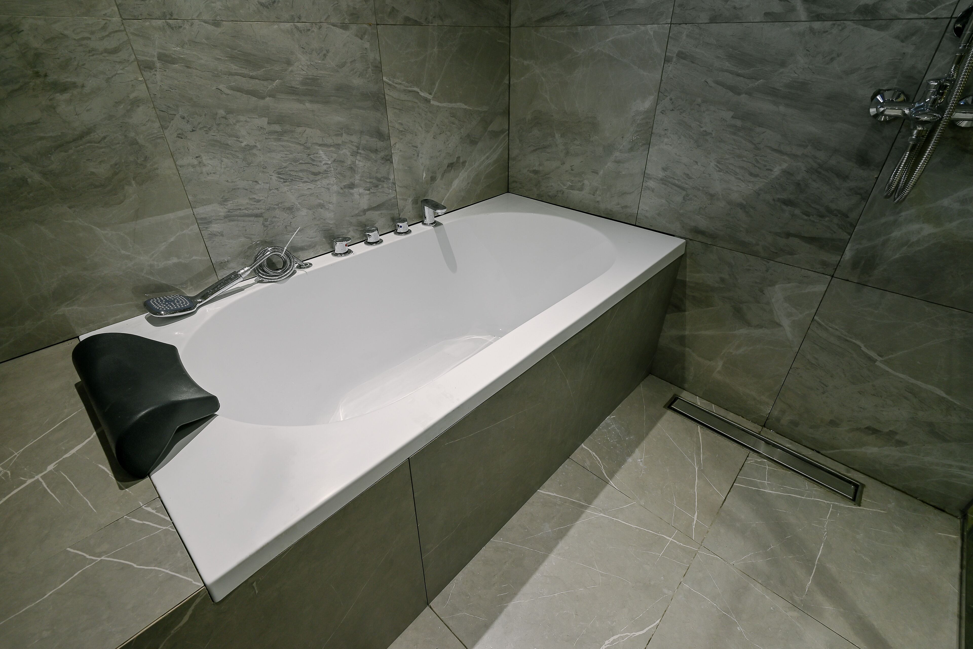 A modern bathroom with a bathtub, a shower, and a toilet.
