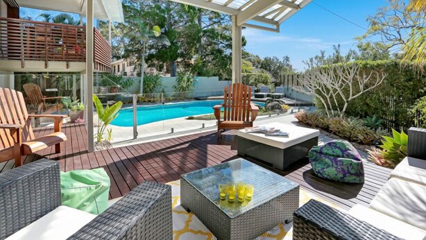 A covered outdoor area with a pool, seating, and plants. - The Lighthouse on Noosa Hill (Noosa Heads)