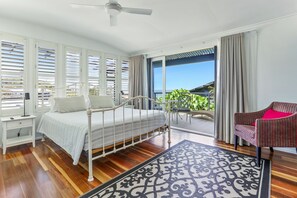 Relax in this serene bedroom with a large bed, ceiling fan, and comfortable seating area.