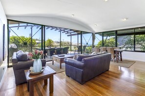 Relax in this spacious living area with expansive views of the surrounding landscape, featuring a comfortable sofa and smaller couch.