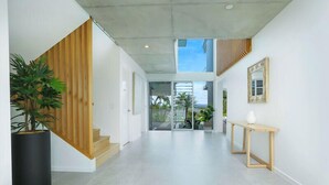 Um interior moderno com uma escada, uma mesa consola e uma planta em vaso.