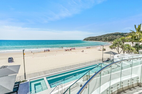 Enjoy a beachfront pool with ocean views from the adjacent glass-enclosed balcony.