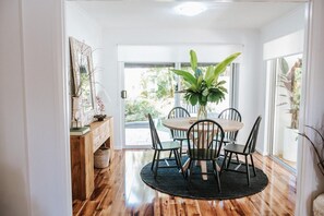 Enjoy meals in this cozy dining area with a round table, comfortable chairs, and a beautiful potted plant.