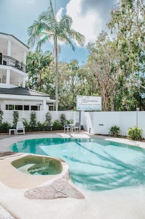 Relax by the serene pool surrounded by lush greenery and a tranquil atmosphere.