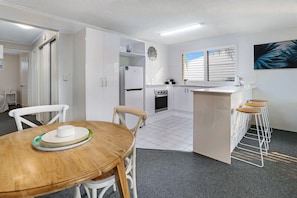 Enjoy meals in this kitchen with an oven and refrigerator, and dine at the adjacent table.