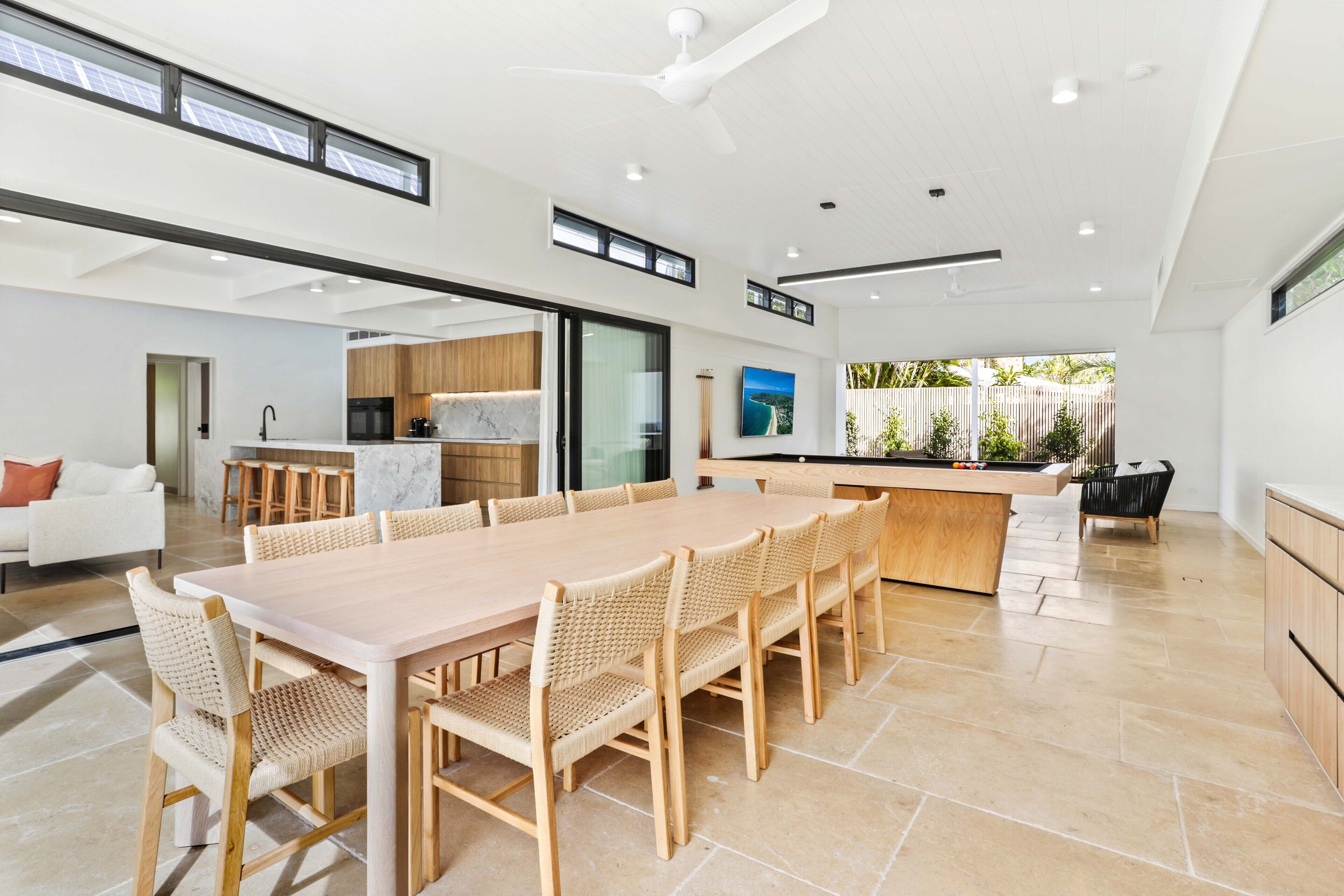 Una cocina moderna y espaciosa con un amplio comedor, una isla integrada y vistas al exterior.