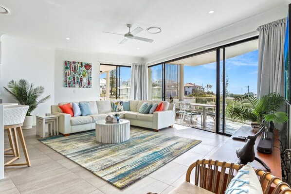 Relax in this inviting living space with a large sofa, coffee table, and dining area.