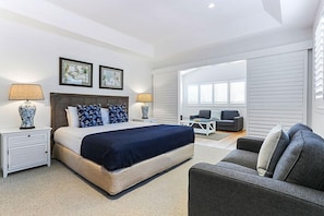 Relax in a serene space with a large bed, two bedside tables, and a comfortable sofa.