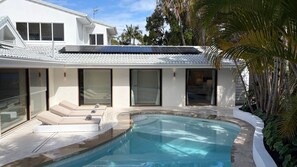 A modern house with a swimming pool, large windows, and solar panels. - Island living in the heart of Noosa (Noosa Heads)