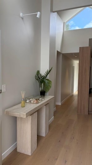 A modern interior with a wooden bench, a potted plant, and a light fixture. - Island living in the heart of Noosa (Noosa Heads)