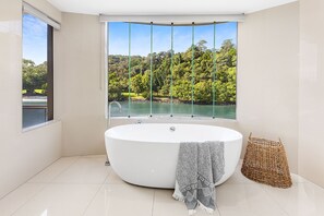 Relax in a spacious bathroom with a bathtub and a view of the surrounding landscape.