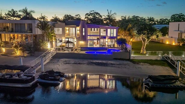 A modern multi-story house with a swimming pool, docked boats, and a well-lit outdoor area. - 31 Witta Circle, Noosa Heads (Noosa Heads)
