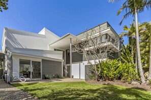 Stylish two-story residence with a covered driveway and beautifully manicured lawn.