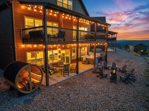 A two-story wooden building with a balcony, outdoor seating, and a hot tub. - Lazy River, Pools, Lake View, Sauna, Sleeps 27 (Kimberling City)