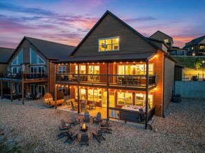 A two-story wooden building with a balcony, outdoor seating area, and a fire pit.