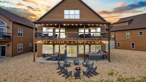 Ein zweistöckiges Holzhaus mit Balkon, Außenbereich zum Sitzen und Lichterketten.