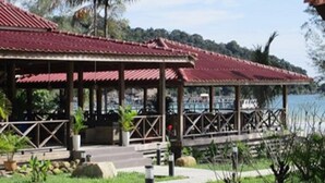A covered outdoor area with a red roof, a concrete pathway, and greenery. - Saracen Bay Resort (Koh Rong Sanloem)