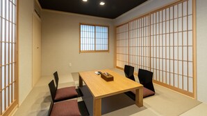 A traditional Japanese-style room with tatami flooring, a low wooden table, and shoji screens.