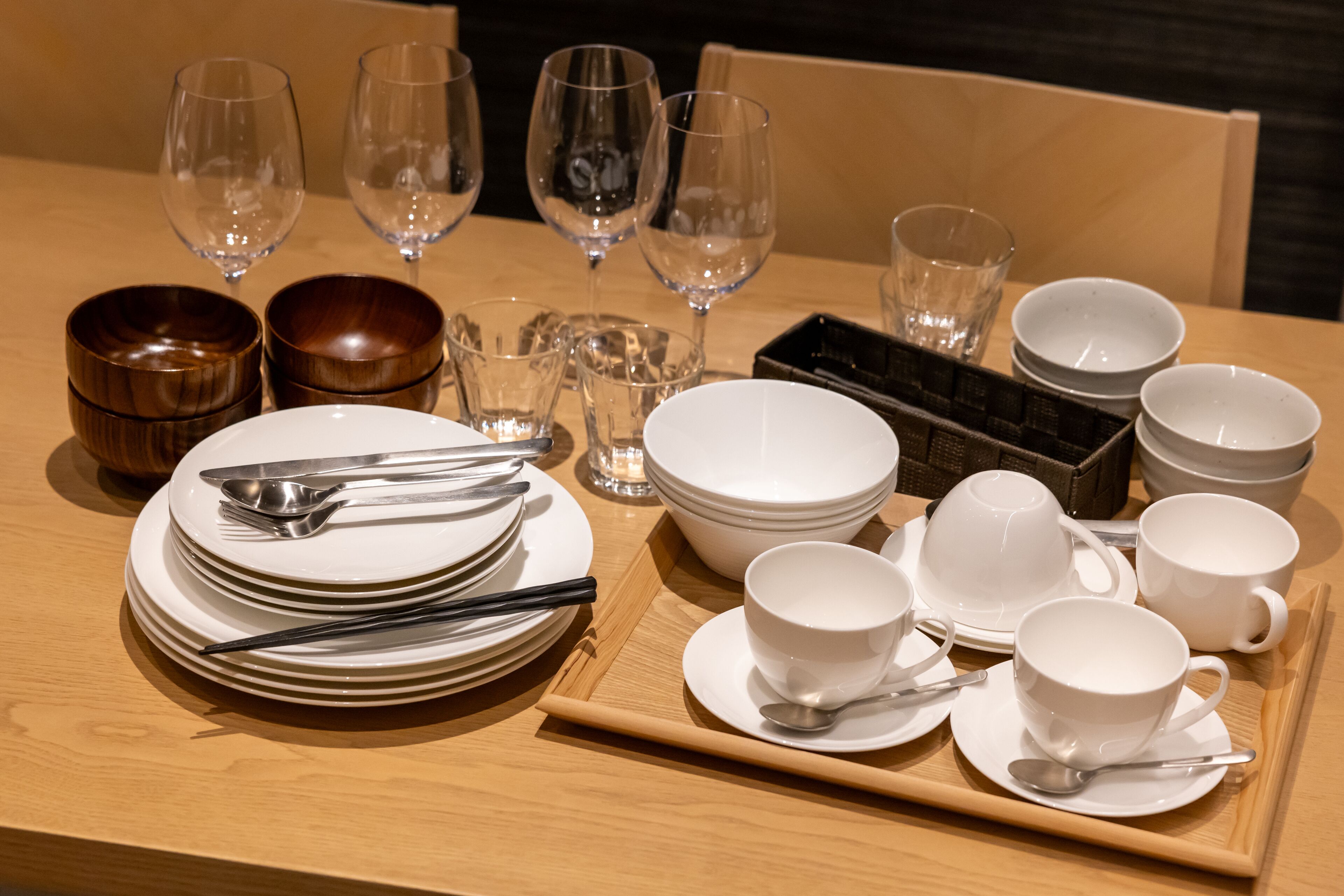 Una mesa de comedor ordenada con platos, tazones, tazas y cubiertos.