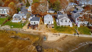 An aerial view of a residential area with houses, a sandy beach, and autumn foliage. - Beach Pass-Charming Waterfront Cottage in Wareham (Wareham)