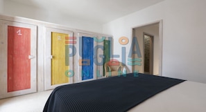 A room with a bed, a chair, and three doors numbered 1, 2, and 3.