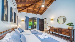 Une chambre d’hôtel avec deux lits, un plafond en bois, un bureau et une vue sur l’extérieur.
