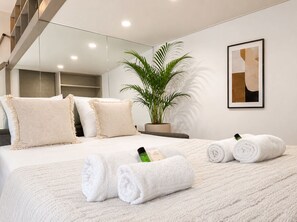 A modern hotel room with a large bed, a potted plant, and a framed artwork on the wall. - Stylish studio near the Tuileries Gardens (Paris)