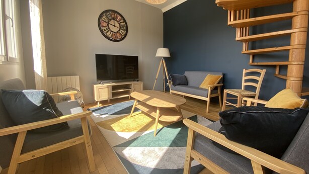 A modern living room with a flat-screen TV, wooden furniture, a clock, and a unique wooden spiral staircase.