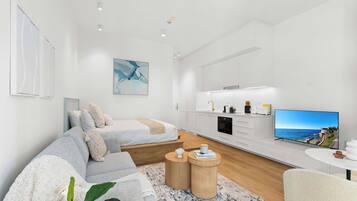 Un salon moderne et minimaliste, avec un canapé, une table basse et un téléviseur à écran plat.